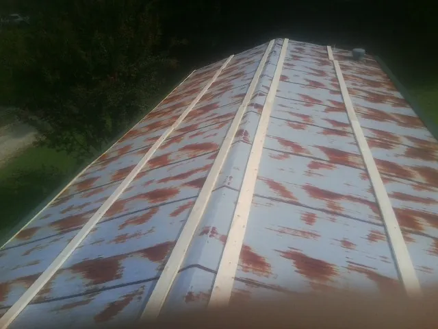 Rusted metal roof panels with new wood purlins before replacement — Storm Damage Roof Repair in Grimsley by Roofing Brothers