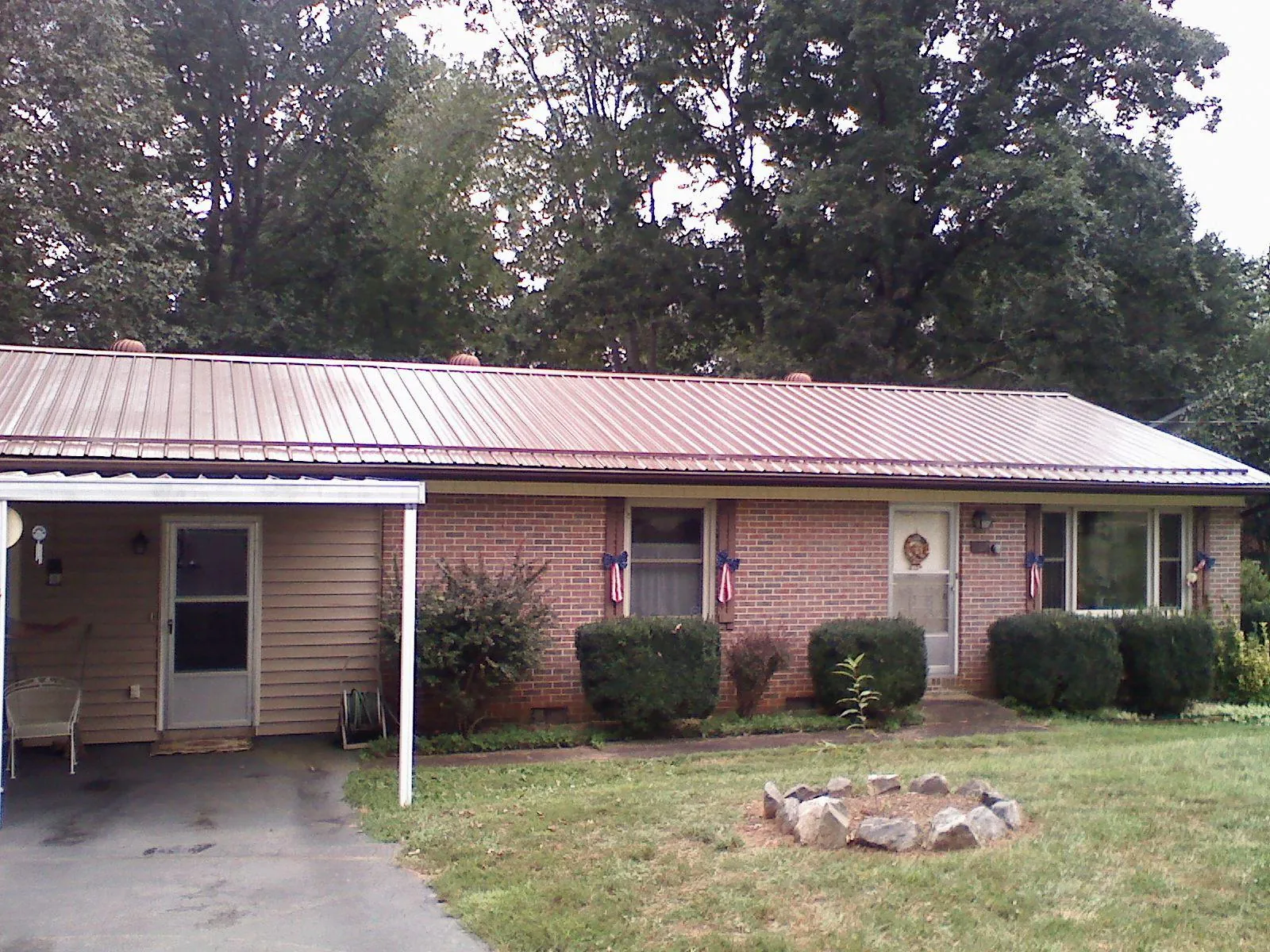Bronze metal roof and carport on a brick ranch home — Roof Repair work by our crew in Grimsley